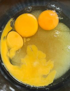 two eggs are being cooked in a pot with water and oil on the stove top