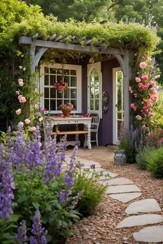 a garden shed with flowers and plants around it