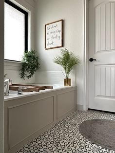 a bathroom with a potted plant on the counter next to a bathtub and sink