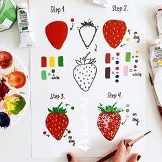 someone is painting strawberries on a white paper