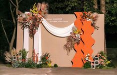 an orange and white wedding arch decorated with flowers