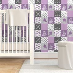 a baby's room with a crib and wallpaper