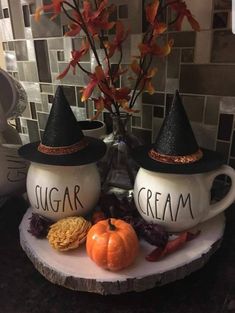 two coffee mugs decorated with witches hats and pumpkins are sitting on a table