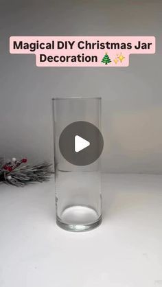 a glass vase sitting on top of a white table next to a christmas decoration sign