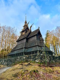 an old wooden building with a steeple on top in the middle of a forest