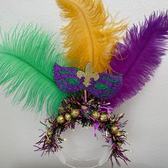 a mardi gras mask is adorned with feathers