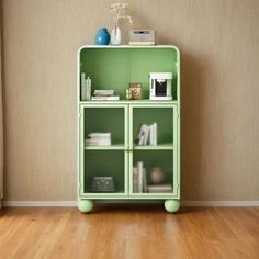 a green bookcase with books on top of it