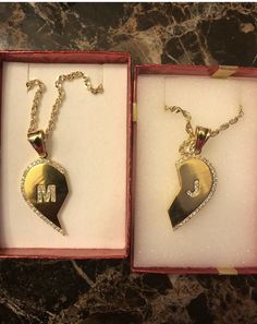 two necklaces in boxes sitting on a table