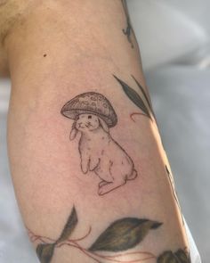 a person with a tattoo on their arm and the image of a rabbit under a mushroom