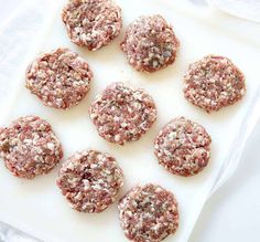 raw meat patties on a white cutting board