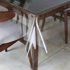 a glass table with some chairs around it and a white ribbon on the chair back