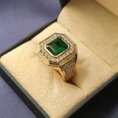 Introducing our exquisite Green Emerald Ring for men, a true testament to luxury and style. This magnificent piece features a captivating 3.25 carat natural green emerald, elegantly cut into a stunning 10X8mm emerald shape. The emerald's deep, vibrant hue is a symbol of vitality and prosperity. Surrounding the emerald is a halo of shimmering round diamonds, adding a brilliant touch of sparkle and enhancing the emerald's beauty. Each diamond has been carefully selected for its exceptional quality Luxury Green Men's Ring With Accent Stones, Luxury Victorian Men's Oval Ring, Gold Emerald Ring For Men, Mens Emerald Ring, Men Emerald Ring, Men’s Emerald Ring, Emerald Ring Design For Men, Emerald Rings For Men, Men’s Ring