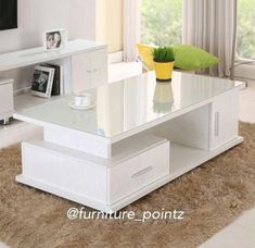 a white coffee table with drawers and a vase on top