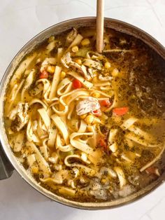 a pot filled with pasta and vegetables on top of a table