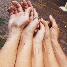 four people holding hands with small dots on their fingers