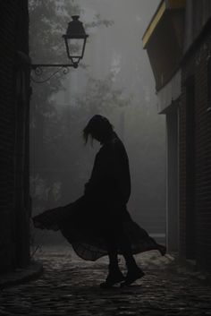 a woman walking down a street in the dark