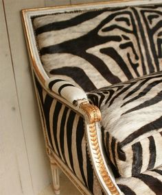 an upholstered zebra print chair with gold trim