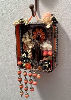 a purse hanging on the wall decorated with beads and flowers