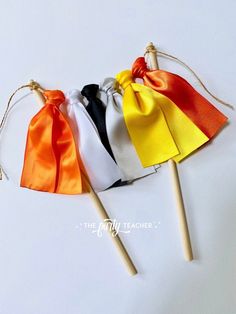 four small candy lollipops tied to wooden sticks with satin ribbons on them