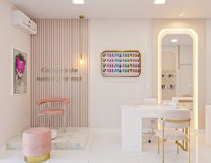 the interior of a nail salon with pink and gold accents on the walls, white countertops, and marble stools