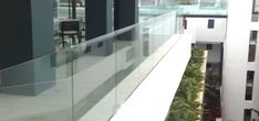 a balcony with glass railings and plants growing on the wall next to each other