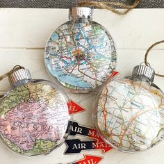 three glass ornaments with maps on them