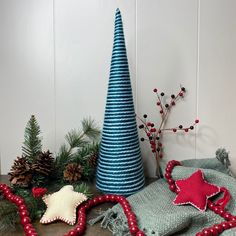 a table topped with christmas decorations next to a blue cone shaped tree and other items