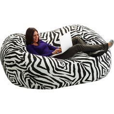 a woman sitting on a bean bag chair with a laptop