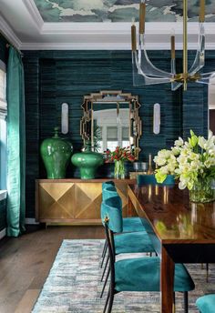 a dining room with blue chairs and green vases