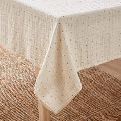 a white tablecloth with black dots on it sitting on top of a wooden table