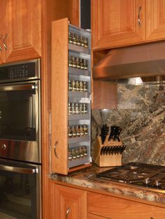 a kitchen with wooden cabinets and stainless steel stove top oven next to an open spice rack