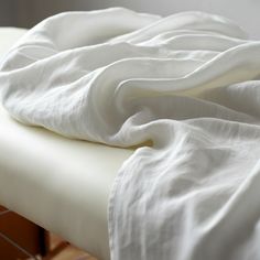 an unmade bed with white sheets on it