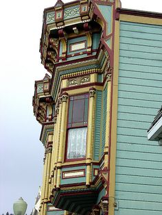 a tall multi - colored building with a clock on it's face and windows