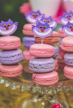 pink macaroons and purple macaroons on a glass plate