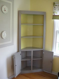 an empty room with yellow walls and white cupboards