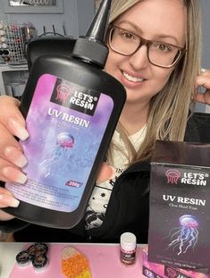 a woman is holding up a bottle of jellyfish resinant and it's contents