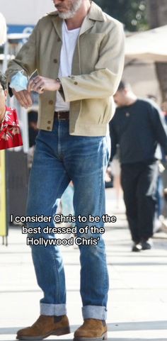 the man is standing on his skateboard and looking down at something in his hand