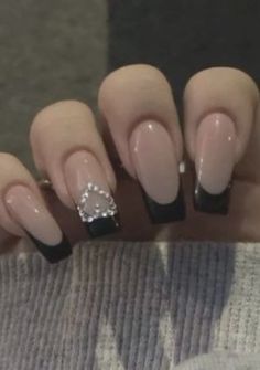 a woman's hand with some black and white nails