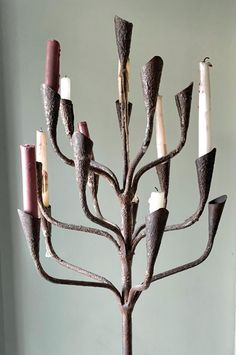 a metal candelabra with candles on it in the shape of a tree