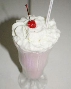 a pink drink with whipped cream and a cherry on top