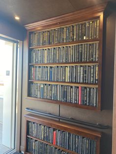 a bookshelf filled with lots of books next to a door and glass window