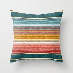 a multicolored striped pillow sitting on top of a white wall