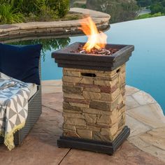 a fire pit sitting on top of a patio next to a swimming pool