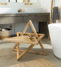 a bathroom with a wooden tray on the floor and a bathtub in the background