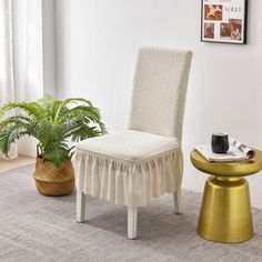 a chair with a skirt on it next to a potted plant in a living room