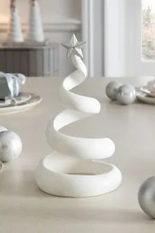 a white christmas tree sitting on top of a table next to silver balls and ornaments