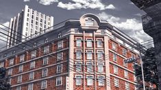 a red brick building sitting on the side of a road next to tall buildings and power lines