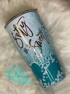 a blue and white tumbler sitting on top of a fur covered floor next to a sign