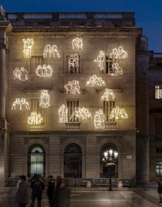 people are standing in front of an illuminated building