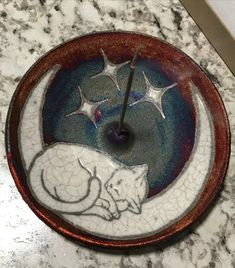 a clock that is sitting on top of a marble counter with stars and a cat sleeping on the moon